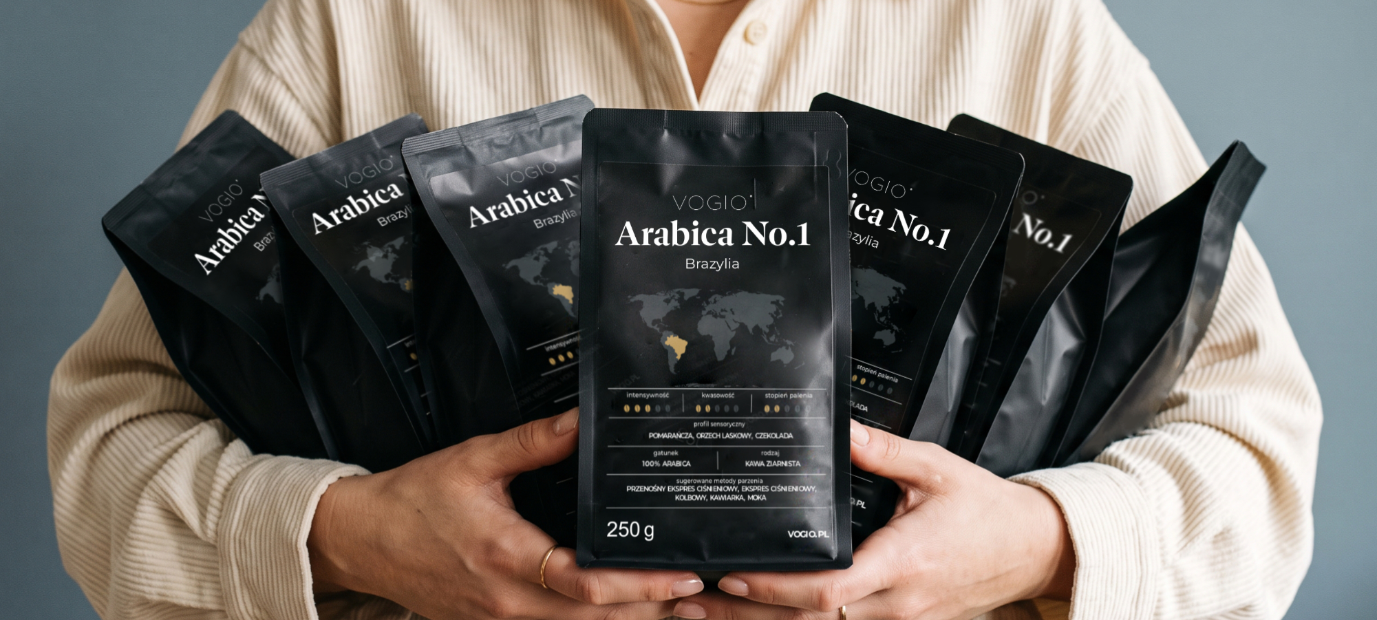 Opakowania kawy ziarnistej VOGIO Arabica No.1 trzymane w dłoniach